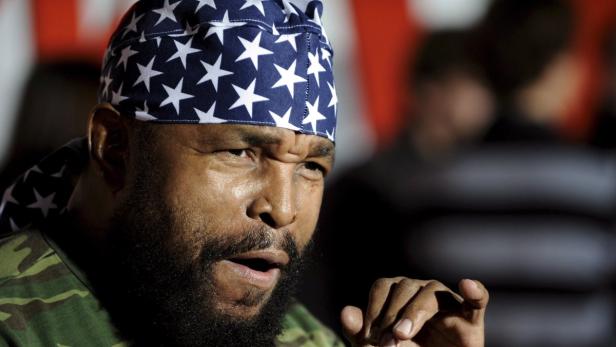 Mr. T mit einem blau-weissen Stirnband mit Sternen und einem Camouflage-Shirt.