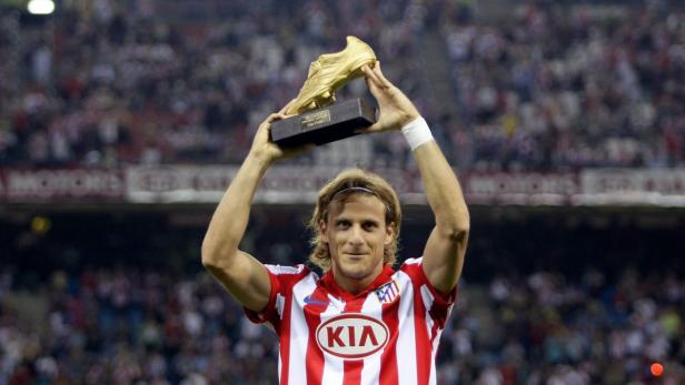 Diego Forlán hält eine goldene Trophäe in Schuhform über seinen Kopf.