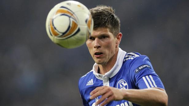 Ein Fußballspieler in einem blauen Trikot köpft einen Ball.