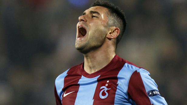 Ein Fußballspieler schreit mit offenem Mund, während er ein Trikot von Trabzonspor trägt.