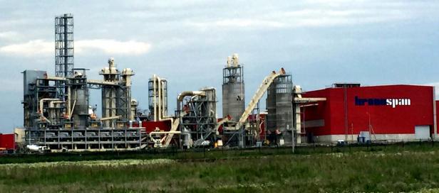 Eine Industrieanlage mit dem Schriftzug „Kronospan“ an einem roten Gebäude.