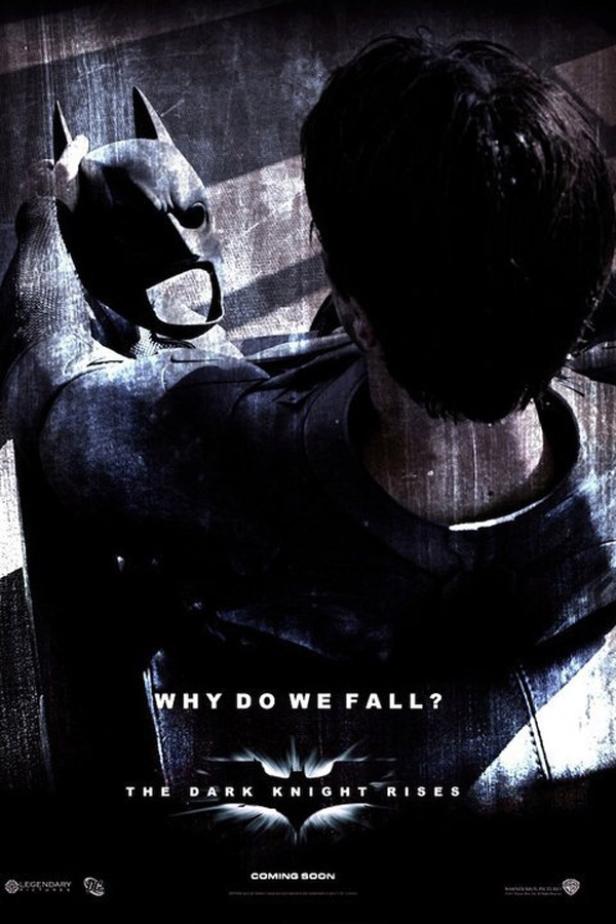 Ein Mann betrachtet die Batman-Maske und den Anzug auf dem Filmplakat zu „The Dark Knight Rises“.