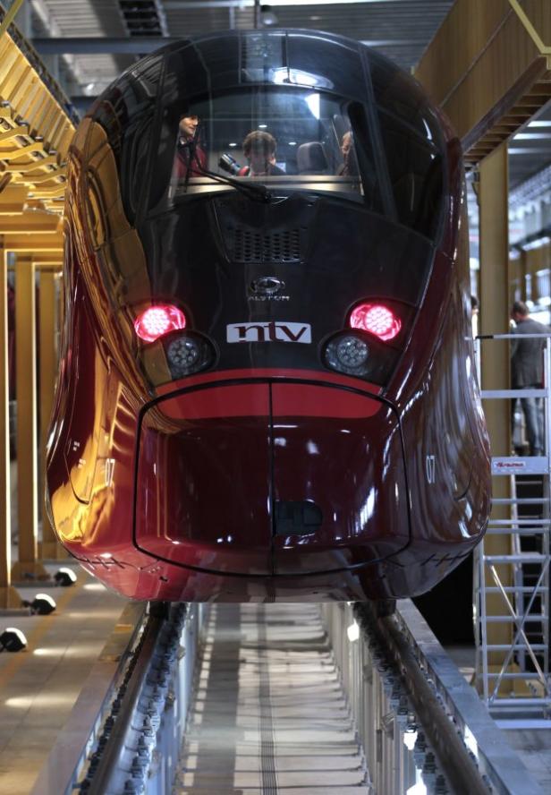 Ein moderner, rotbrauner Hochgeschwindigkeitszug der Marke Alstom steht auf einem Gleis.