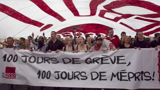 Eine Gruppe von Demonstranten hält ein Banner mit der Aufschrift „100 Tage Streik, 100 Tage Verachtung!“.