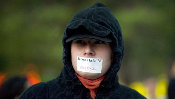 Eine Person mit einem Aufkleber „Sabotez la loi 78“ über dem Mund.