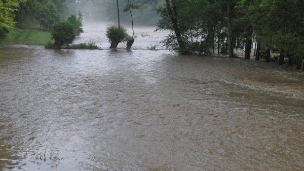Ein über die Ufer getretener Fluss überschwemmt das Umland.
