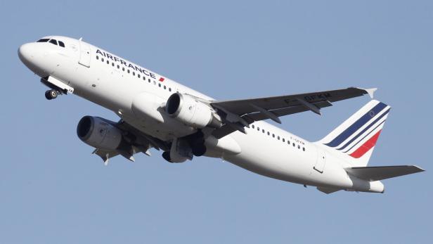 Ein weißes Air France Flugzeug startet vor blauem Himmel.