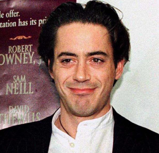 Ein Porträt von Robert Downey Jr. vor einem Filmposter.