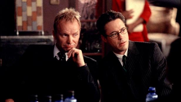 Sting und Robert Downey Jr. sitzen zusammen in Anzügen.