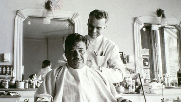 Ein Mann bekommt in einem Friseursalon die Haare geschnitten.
