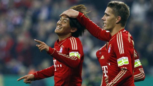 Zwei Fußballspieler des FC Bayern München feiern ein Tor.