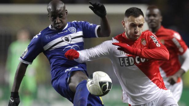 Zwei Fußballspieler kämpfen um den Ball während eines Spiels.