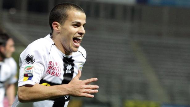 Ein Fußballspieler in einem schwarz-weißen Trikot jubelt mit geöffnetem Mund.