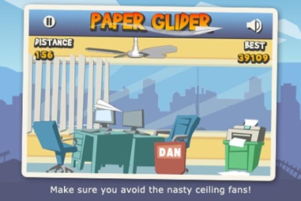 Paper Glider/App/iTunes - 10milliardste App Ein Bildschirmfoto des Spiels „Paper Glider“ in einem Büroraum.