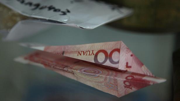 Ein Papierflieger, gefaltet aus einem chinesischen Yuan-Geldschein.
