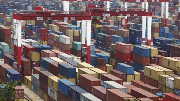 Ein Containerterminal mit vielen bunten Frachtcontainern und Kränen.