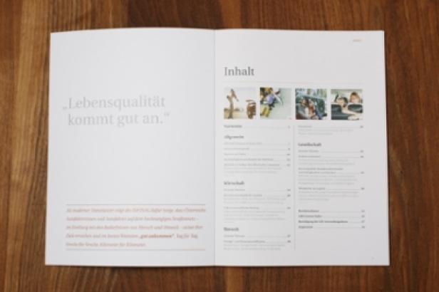 Asfinag/Nachhaltigkeitsbericht/identum Eine geöffnete Broschüre mit dem Titel „Inhalt“ liegt auf einem Holztisch.