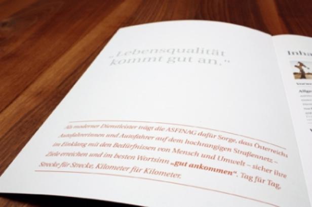 Asfinag/Nachhaltigkeitsbericht/identum Eine geöffnete Broschüre mit dem Zitat „Lebensqualität kommt gut an.“.