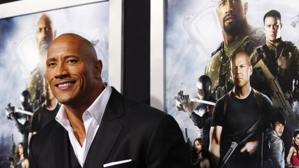 Dwayne „The Rock“ Johnson posiert vor einem Filmposter von „G.I. Joe: Die Abrechnung“.