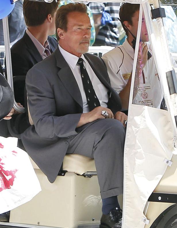 Arnold Schwarzenegger sitzt in einem Golfwagen.