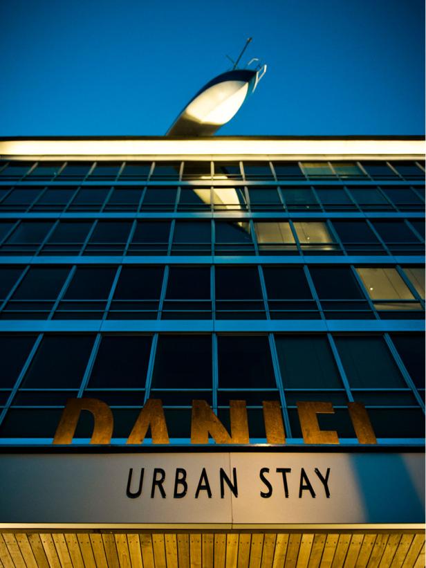 Das Hotel „Daniel Urban Stay“ mit einer skulpturalen Yacht auf dem Dach.