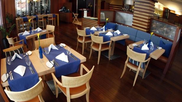 Einladende Tische mit blauen Tischläufern in einem eleganten Restaurant.