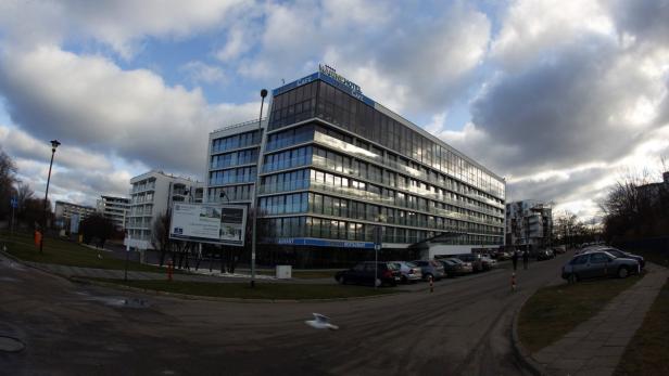 Das Marine Hotel und Café an einer Straße mit geparkten Autos.