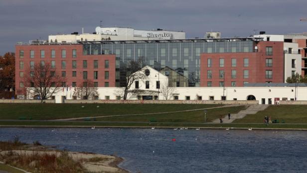 Das Sheraton Hotel in Krakau, Polen, überblickt einen Fluss mit Schwänen.