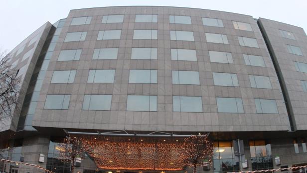 Ein großes Bürogebäude mit vielen Fenstern und einer Lichterkette am Eingang.