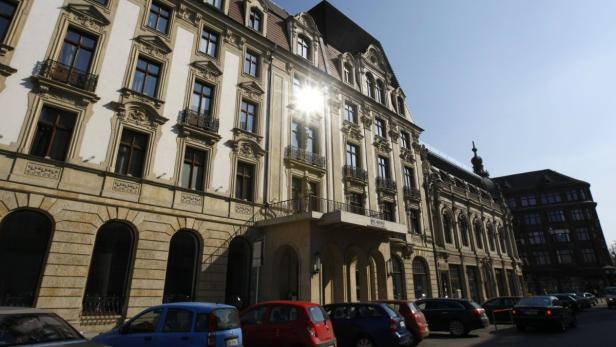 Ein großes, verziertes Gebäude mit geparkten Autos davor.