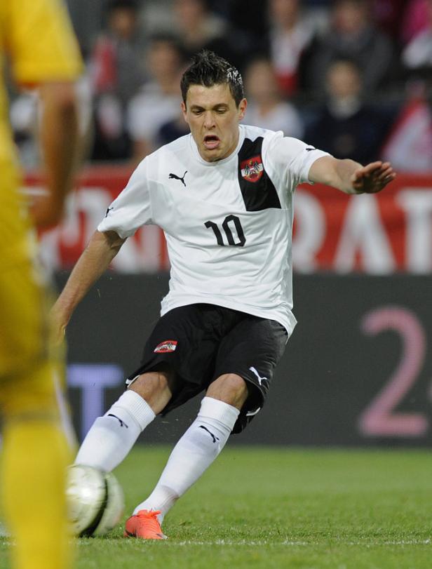 Ein österreichischer Fußballspieler im weißen Trikot mit der Nummer 10 beim Schuss aufs Tor.