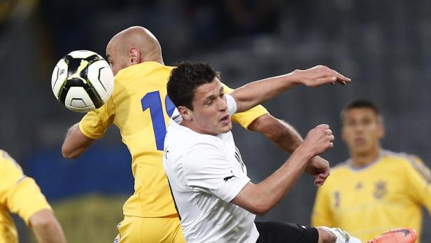 Zwei Fußballspieler kämpfen um den Ball während eines Spiels.