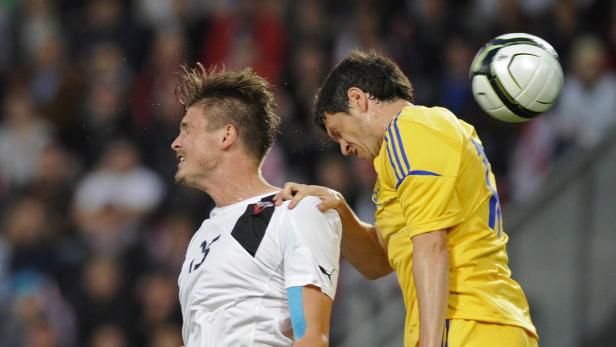 Zwei Fußballspieler während eines Spiels, einer berührt den anderen an der Schulter.