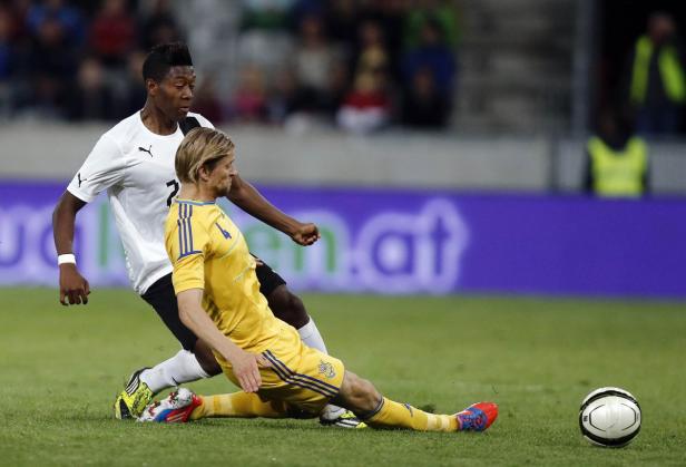 Zwei Fußballspieler kämpfen um den Ball auf dem Spielfeld.