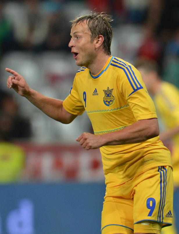 Ein ukrainischer Fußballspieler in gelber Spielkleidung gestikuliert auf dem Spielfeld.