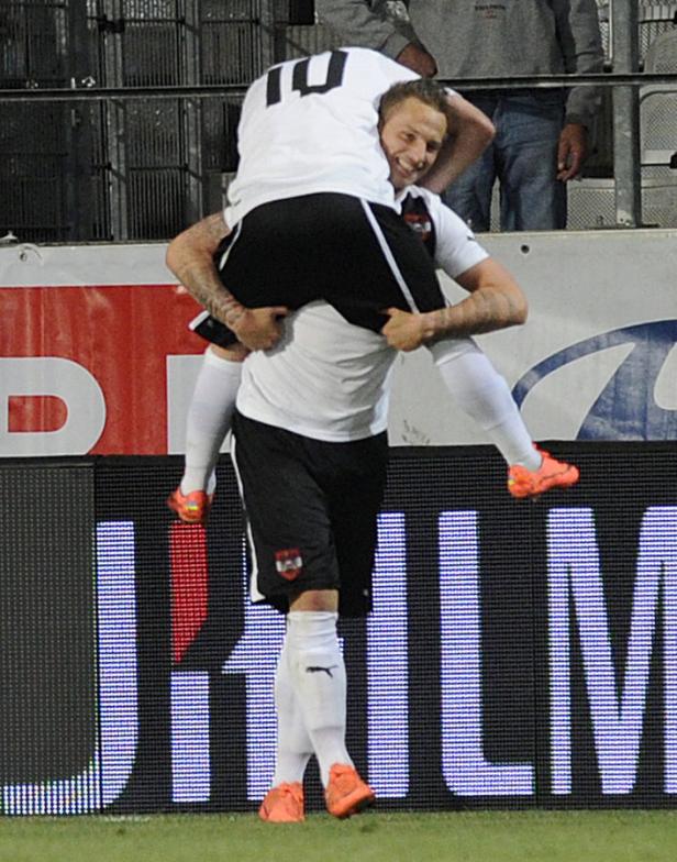 Ein Fußballspieler trägt einen anderen Spieler huckepack.