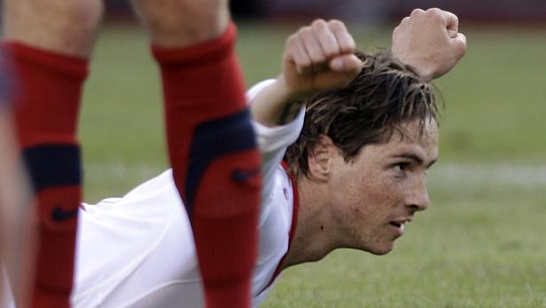 Ein Fußballspieler liegt auf dem Rasen und jubelt mit geballten Fäusten.