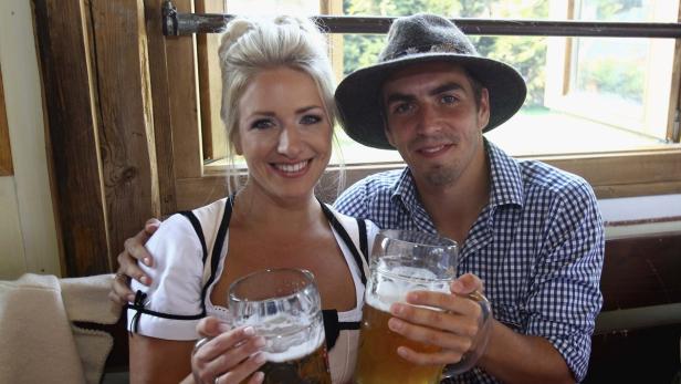 Ein Paar in Tracht hält Bierkrüge in die Kamera.