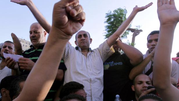 Eine Gruppe von Menschen demonstriert mit erhobenen Fäusten.