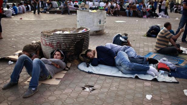 Mehrere Menschen ruhen sich auf einem öffentlichen Platz aus.