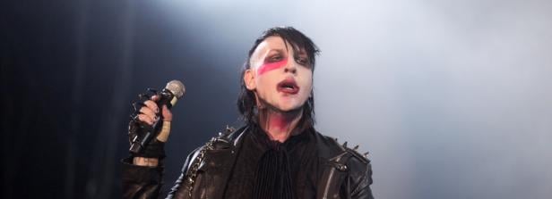 Marilyn Manson singt mit einem Mikrofon in der Hand.
