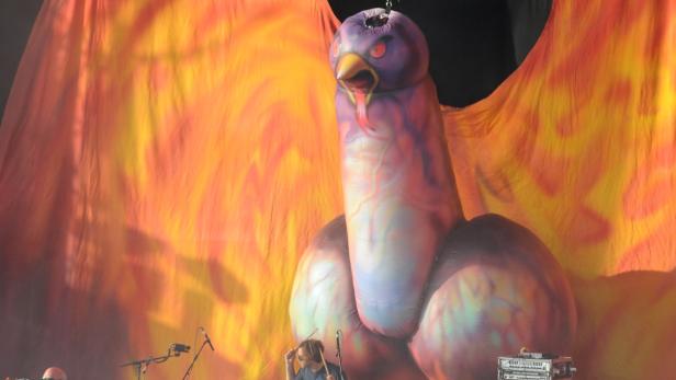 Ein riesiger, aufblasbarer Vogel mit ausgebreiteten Flügeln steht auf einer Bühne.