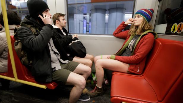 Mehrere Personen in Shorts sitzen in einem Zug.