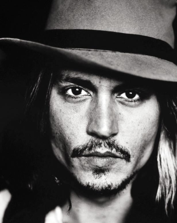 Schwarzweißporträt von Johnny Depp mit Hut und Bart.