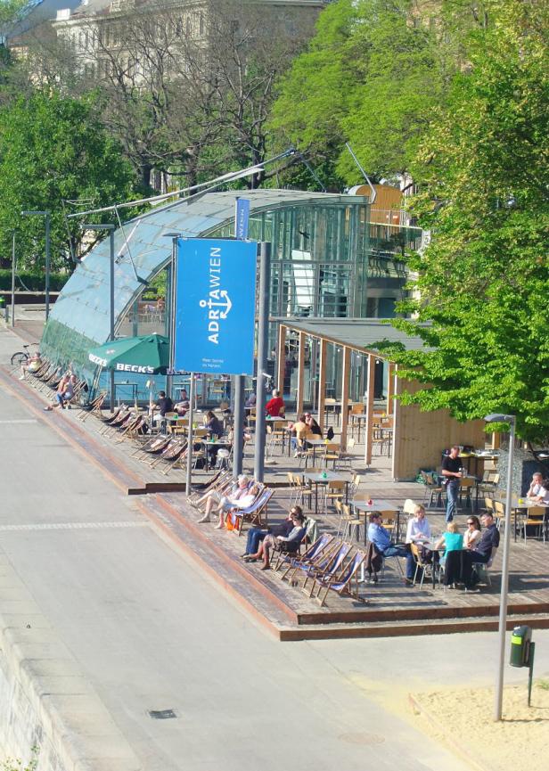Menschen entspannen sich im Sommer im Adria Wien am Donaukanal.