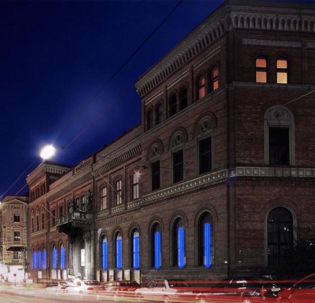 Ein Backsteingebäude mit blauen Lichtern in den Fenstern bei Nacht.