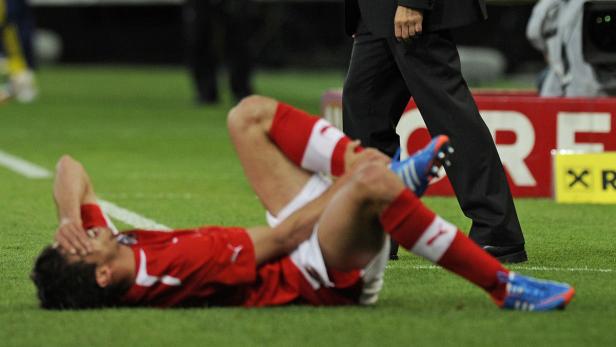 Ein Fußballspieler liegt verletzt auf dem Rasen.