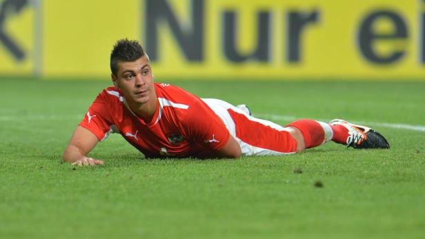 Ein österreichischer Fußballspieler liegt auf dem Rasen.