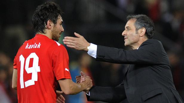 Ein Fußballspieler mit der Nummer 19 und dem Namen Kavlak gibt einem Trainer die Hand.