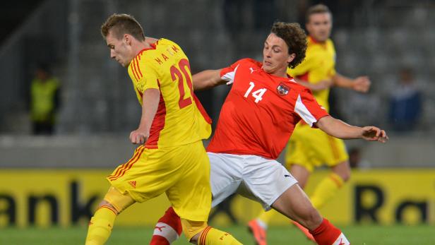 Zwei Fußballspieler kämpfen um den Ball während eines Spiels.